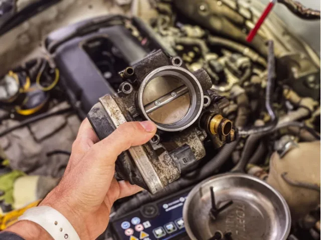 Where is the throttle valve located in a car?