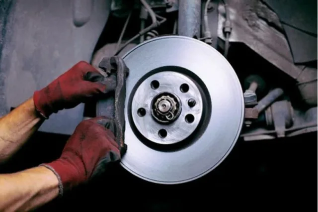 How does the brake pad wear sensor work and where is it located?