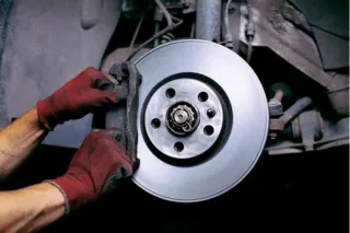 How does the brake pad wear sensor work and where is it located?