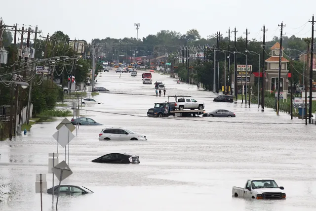 car_gets_towed_while_men_walk_in_the_flooded_waters_of_news_photo.jpg